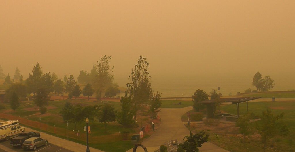 Regular sight camera looking over river during wildfire